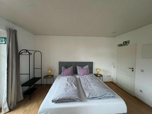 a bedroom with a large white bed with pink pillows at Villa Theresia in Benediktbeuern