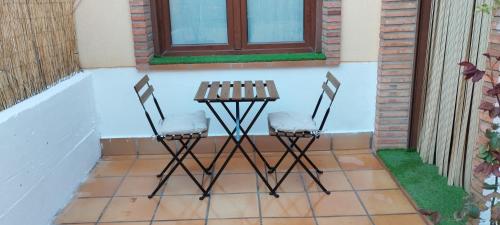 two chairs and a table on a patio at Casa La Parra en Teruel in Villastar