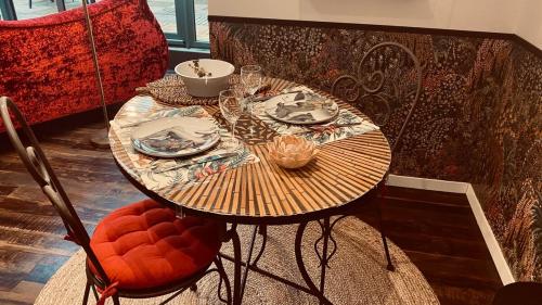 a table with plates and glasses on top of it at Romantique Love Room L Amour sous les Tropiques in Sémussac