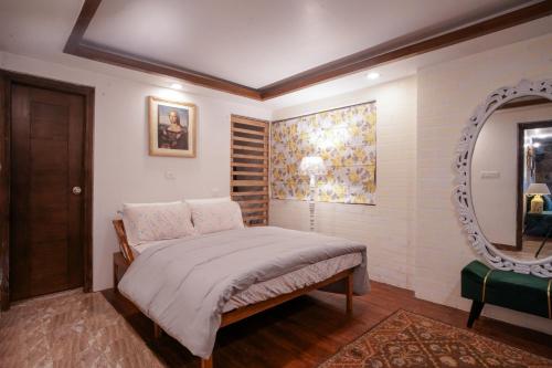 a bedroom with a bed and a mirror at Woodburry Mansion, Cozy Nainital Homestay in Nainital