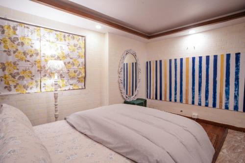 a bedroom with a bed and a painting on the wall at Woodburry Mansion, Cozy Nainital Homestay in Nainital