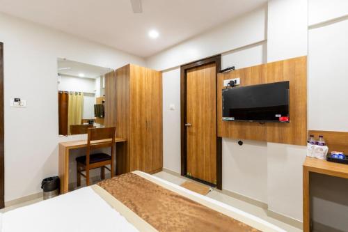 a hotel room with a bed and a flat screen tv at Galaxy Stays BKC in Mumbai