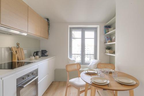 une cuisine avec une table et des chaises dans une pièce dans l'établissement Cocon chaleureux, 4 pers, Lyon 6ème, à Lyon