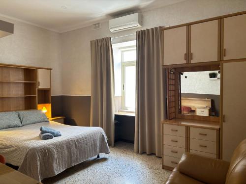 a bedroom with a bed and a dresser and a mirror at Balluta Hill House in Sliema