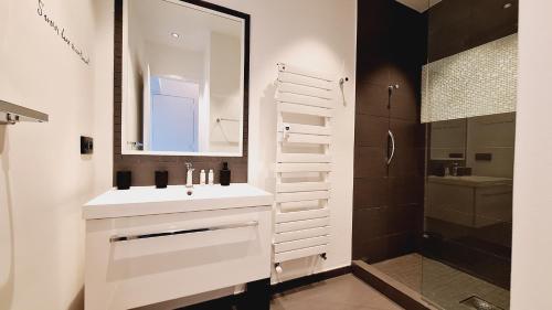 une salle de bain blanche avec un lavabo et un miroir dans l'établissement Superbe loft avec terrasse Cannes Montfleury, à Cannes