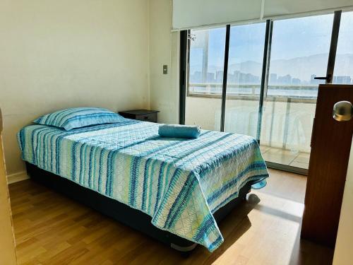 a bedroom with a bed and a large window at Departamento en Santiago cercano a aeropuerto y metro in Santiago