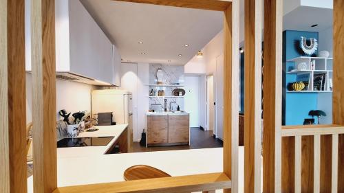 - une cuisine avec des placards blancs et des murs bleus dans l'établissement Superbe loft avec terrasse Cannes Montfleury, à Cannes