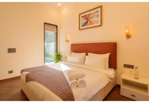 una camera da letto con un letto grande con due asciugamani sopra di TelferkStays 4BHK Luxurious Villa ad Anjuna