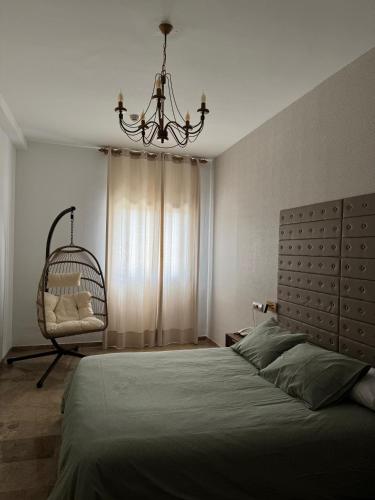 a bedroom with a bed and a chandelier at Hotel Sierra de Quesada SL in Quesada