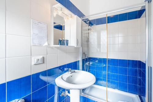 a blue and white bathroom with a sink and a shower at Al Palmento Relais in Siracusa