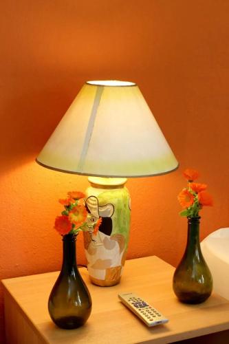 two vases on a table with a lamp and a remote control at ODYSSEIA Camping & Bungalows in Katerini