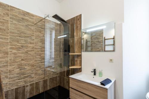 une salle de bain avec un lavabo et une douche dans l'établissement Appartement de caractère, à Sarlat-la-Canéda