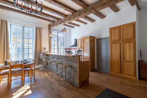 - une cuisine avec un bar, une table et des chaises dans l'établissement Appartement de caractère, à Sarlat-la-Canéda