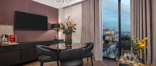 a dining room with a table and chairs and a window at Komana Hotel Binbirdirek in Istanbul