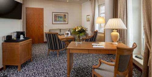 a hotel room with a desk and a room at Hotel Am Jägertor in Potsdam