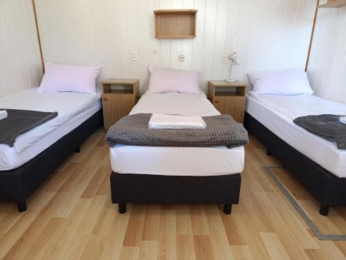 two twin beds in a room with wooden floors at Leśna Osada Tęcza Jabłonowiec in Jabłonowiec