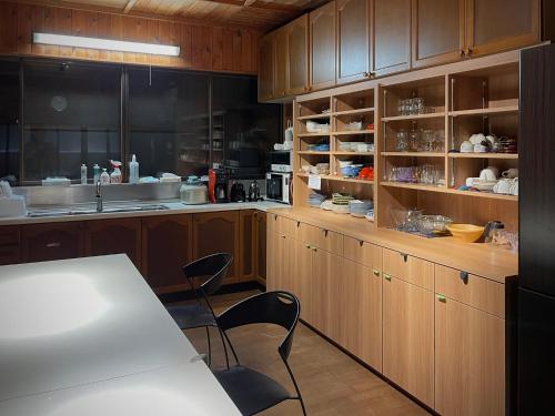 a kitchen with wooden cabinets and a table and chairs at 白華の家 House of Hakka秋田駅秋田空港への送迎可能 in Akita