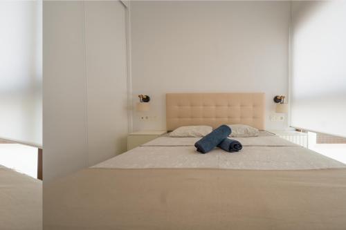 Dormitorio blanco con cama con almohada azul en YourSpain Apartment LM3B, en La Mata
