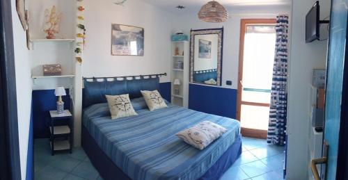 a bedroom with a blue bed with two pillows at Casa Ancora in Massa Lubrense
