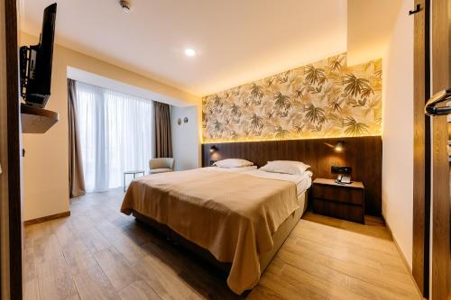 a bedroom with a large bed and a large painting on the wall at Mayak Resort in Kyiv