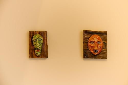 three pictures of masks hanging on a wall at Mayak Resort in Kyiv