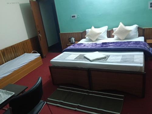 a bedroom with two beds and a table and chairs at Monal Inn in Mīlam