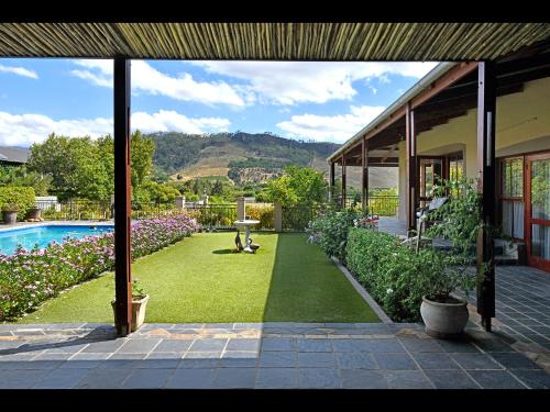 Un patio con piscina y una casa. en The Manor House at Roubaix Estate, en Franschhoek