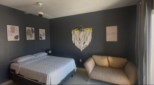 a bedroom with a bed and a chair at Serra Mar Suítes,Lofts, e casas à 300 metros das praias in Arraial do Cabo