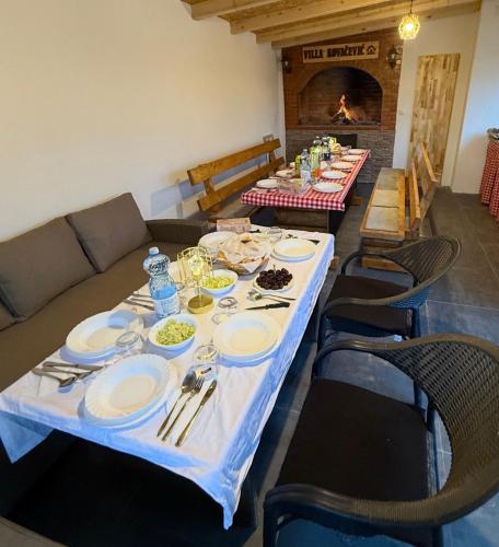 a long table with plates of food on it at Kuća za odmor Villa Kovačević in Bihać