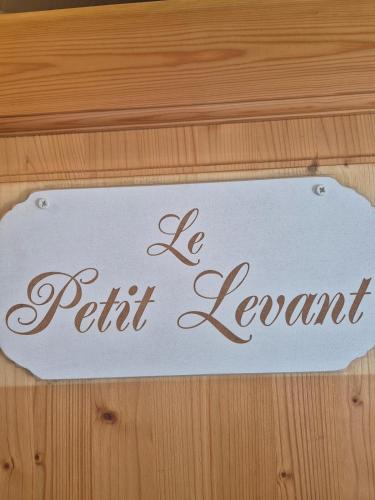 a sign that says be patient leant on a wooden table at Le Petit Levant sea view studio in Cavalaire-sur-Mer