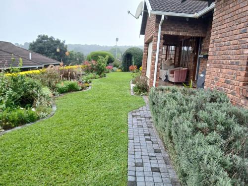 a garden with a brick house and a brick walkway at Hope at Mangaliso in Hilton