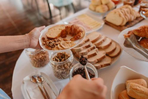 a table filled with different types of bread and pastries at Puerto Dijama Hotel Boutique in Carmelo