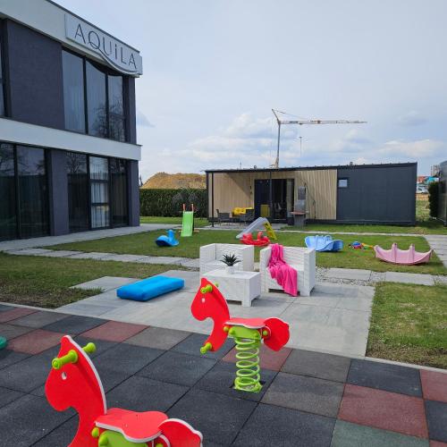 a playground with toy dinosaurs and furniture in front of a building at Aquila Hotel in Zator