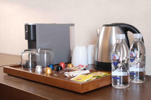 a wooden tray with bottles and a coffee maker on a table at Phellos Suites Boutique Hotel in Şile