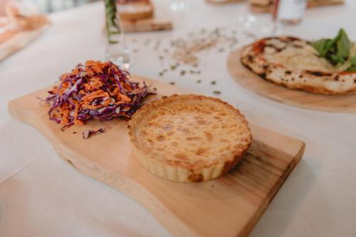 a table with a cutting board with a sandwich and a pizza at Puerto Dijama Hotel Boutique in Carmelo