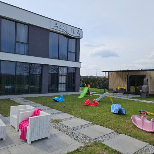 a yard with playground equipment in front of a building at Aquila Hotel in Zator