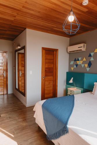 a bedroom with a bed and a wooden ceiling at Puerto Dijama Hotel Boutique in Carmelo
