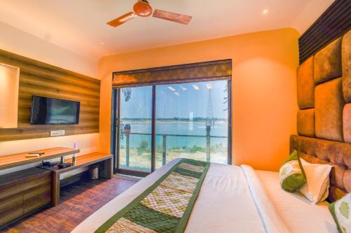 a bedroom with a bed and a desk and a window at Shiv Rudraksh Resort, Near Assi Ghat in Varanasi