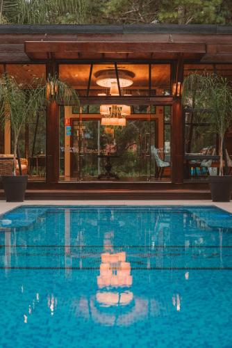 a swimming pool in front of a house at Puerto Dijama Hotel Boutique in Carmelo