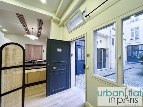 a hallway with a blue door and a kitchen at 05 - Parisian Design Loft in Paris