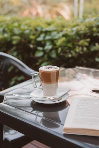 a cup of coffee on a table with a book at Puerto Dijama Hotel Boutique in Carmelo