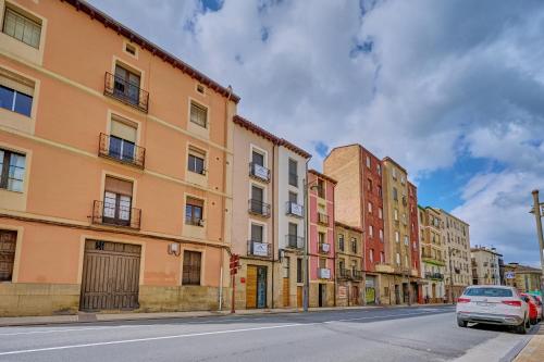 a street with buildings and a car driving down a street at Apartamentos Vinomium by Clabao in Logroño