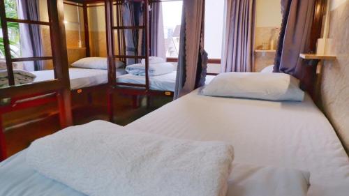a room with three beds and a mirror at Hue Ancient Town - Homestay in Hue in Hue