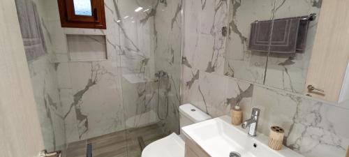 a bathroom with a sink and a toilet and a shower at Victoria's Apartments in Néa Tríglia