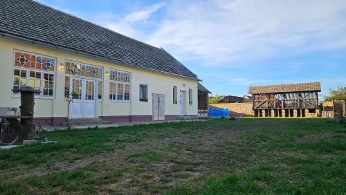 a building and a barn with a grass yard at Kod Bake in Novi Bečej