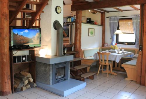 a living room with a fireplace with a tv and a table at Ferienhaus 87 am Silbersee in Frielendorf