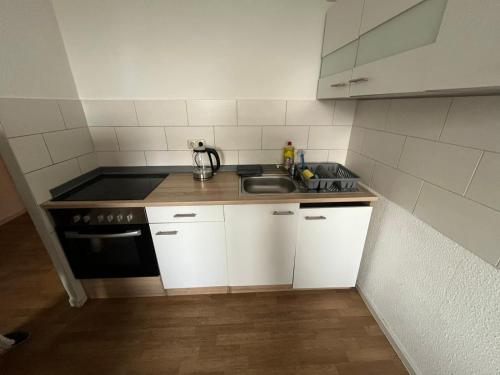 a small kitchen with a sink and a stove at 13 Apartments 3BR R&P Living in Halle an der Saale