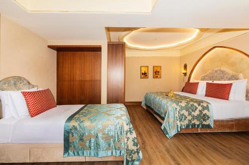a hotel room with two beds and a mirror at Romance Istanbul Hotel Boutique Class in Istanbul