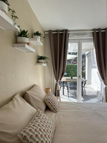 Cette chambre dispose d'un lit avec des oreillers et d'une terrasse. dans l'établissement Au Coin du Verger, à Colmar