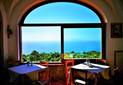 a room with two tables and a large window at Da Gelsomina in Anacapri